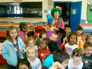 Photo - Greenie with a group of happy kiddos